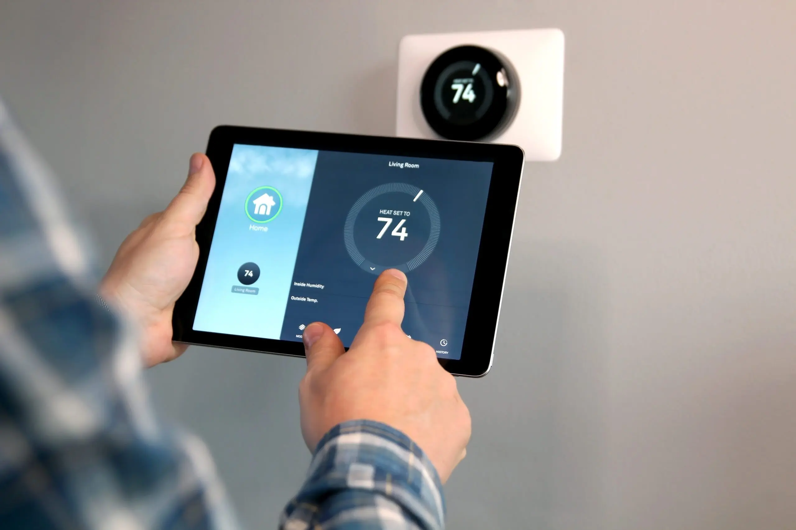Man is Adjusting a temperature using a tablet with smart home a